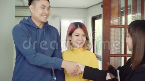 快乐的年轻亚洲夫妇和房地产经纪人开朗的年轻人签署一些文件并与经纪人握手视频的预览图