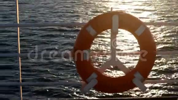 日落时横渡大海的小船上的红色救生圈视频的预览图