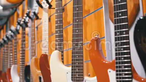 很多电动吉他挂在音乐商店里商店乐器视频的预览图