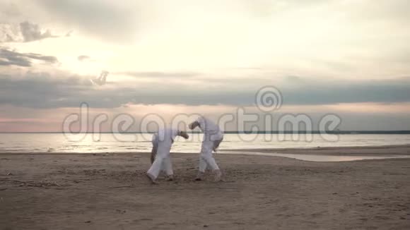 两个人在海滩上练习卡波伊拉视频的预览图