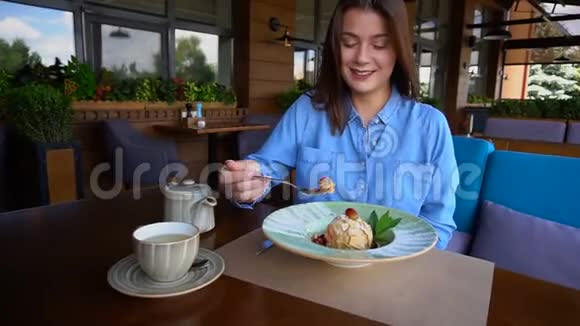 满意的女孩在餐馆慢动作吃甜点视频的预览图