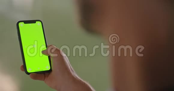 年轻的成年人在健身运动中使用带有绿色屏幕的智能手机格润格工业城市培训4k视频的预览图
