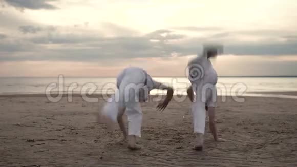 两个人在海滩上练习卡波伊拉视频的预览图