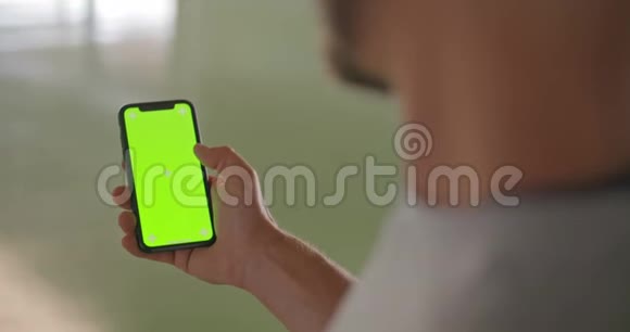 年轻的成年人在健身运动中使用带有绿色屏幕的智能手机格润格工业城市培训4k视频的预览图