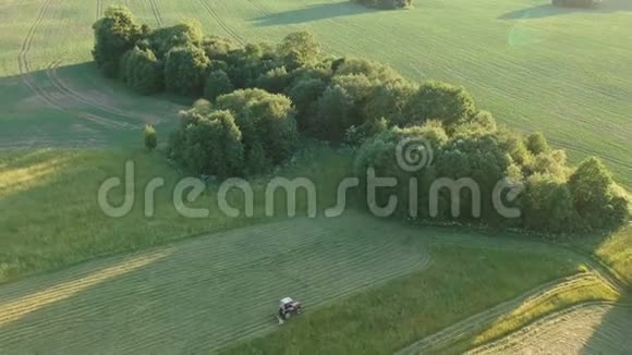 农用拖拉机收割夏草鸟瞰视频的预览图