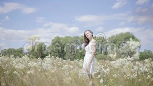 在花草地中间的年轻漂亮的女人慢动作视频的预览图