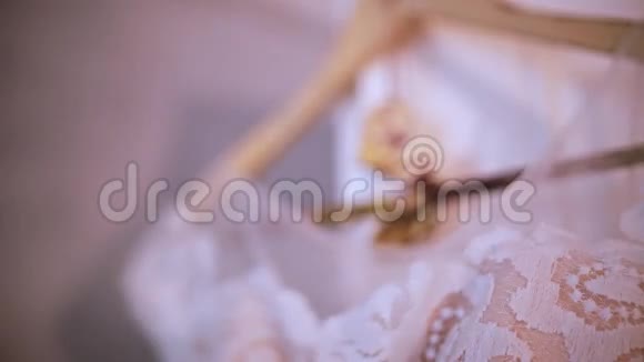 漂亮的白色婚纱挂在卧室的衣架上新娘的早晨准备细节在乡村风格视频的预览图