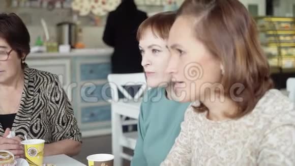 女人在咖啡馆里喝茶在咖啡厅喝杯茶的同事讨论工作计划视频的预览图