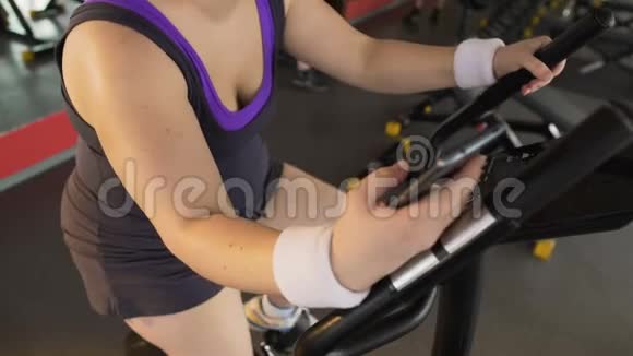 健身应用肥胖女孩骑运动自行车和滚动移动视频的预览图