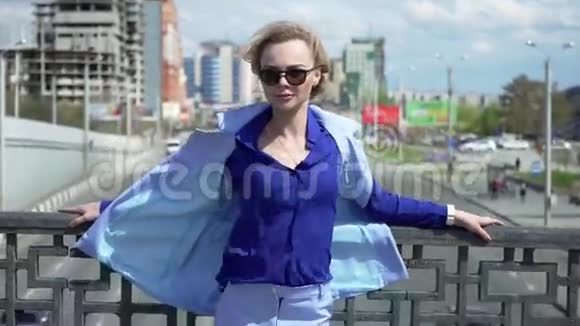 美丽的商务女性戴着眼镜短发站在桥上汽车的移动视频的预览图