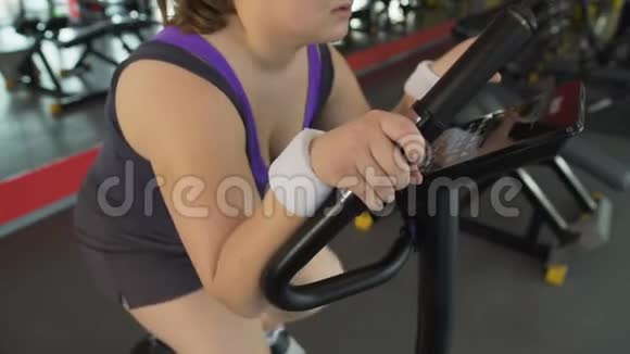 体育俱乐部健身运动中的女性健身自行车视频的预览图