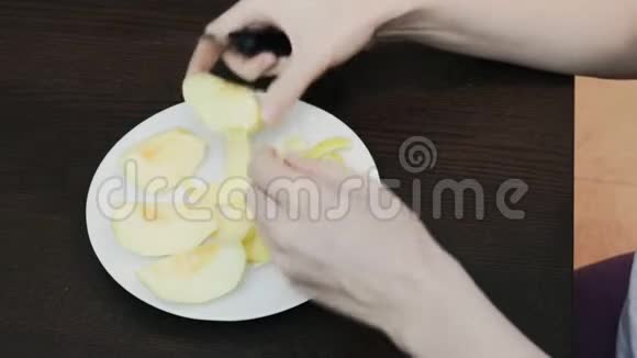 女性用刀子剥去黄色苹果的皮视频的预览图