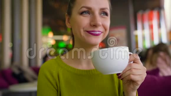 女人在咖啡屋里喝着加奶油的咖啡巧克力糖浆和勺子视频的预览图