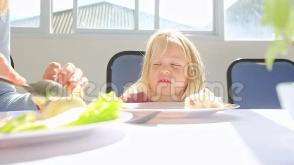 愤怒的小女孩在桌旁等待妈妈的食物视频的预览图