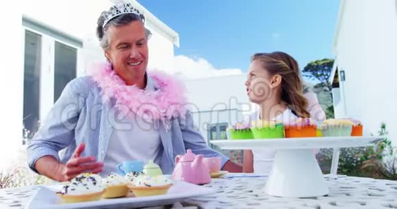 微笑的父亲和女儿穿着仙女服装参加茶会视频的预览图