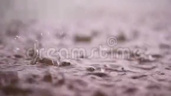 特写镜头大的大雨的降雨的淋浴的用喷雾落下的水溅在水坑潮湿的表面上视频的预览图