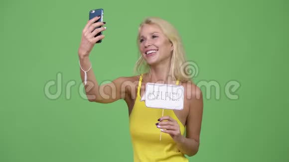 年轻快乐的金发美女带着纸签自拍视频的预览图