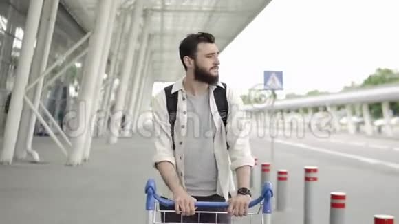 一个满脸胡须的男人拿着背包走路检查他的智能手表视频的预览图