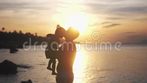 快乐的父亲和女儿一起在热带海滩玩在惊人的日落缓慢的运动3840x2160视频的预览图