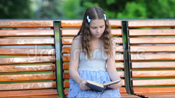 女孩坐在长凳上看书视频的预览图