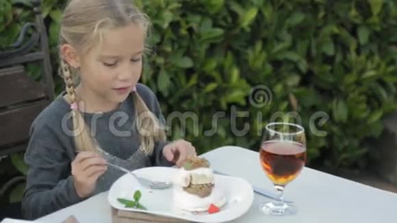 可爱的小女孩扎着辫子吃甜点视频的预览图