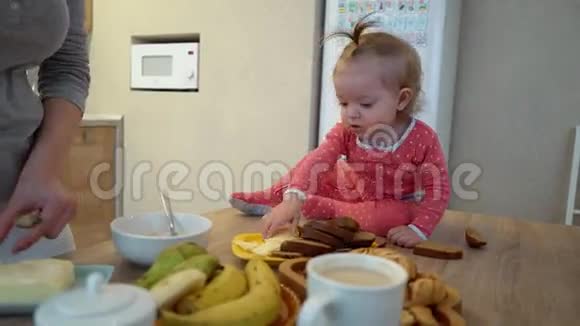 家庭食物孩子营养和亲子观念快乐的年轻母亲和婴儿一起吃早餐视频的预览图