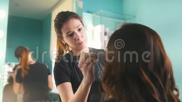 在美容店为年轻的黑发女人化妆为眼睛做视觉视频的预览图