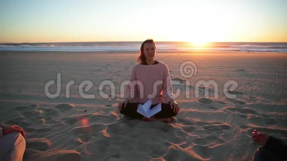 在海滩上和教练一起练习瑜伽视频的预览图