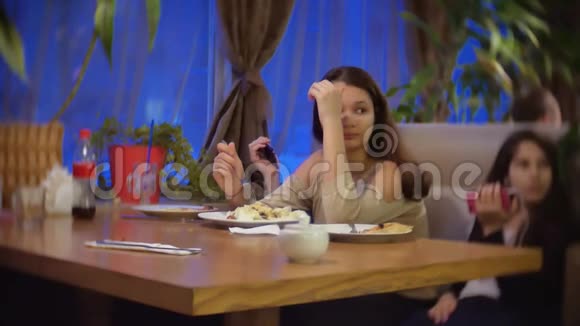 少女坏猿抑郁年龄不想吃沙拉坐在咖啡馆里和朋友一起慢动作视频的预览图