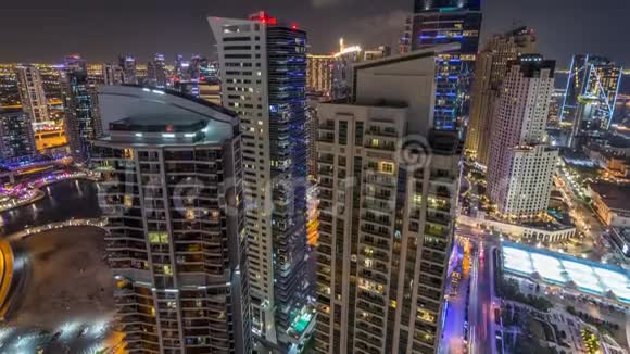 在迪拜Jumeirah海滩住宅JBR和迪拜码头夜间时间推移的现代照明摩天大楼的鸟瞰图视频的预览图