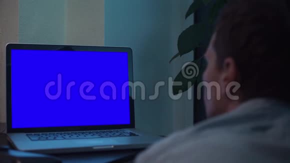 在灶台附近的厨房里看着蓝键笔记本电脑屏幕的人视频的预览图
