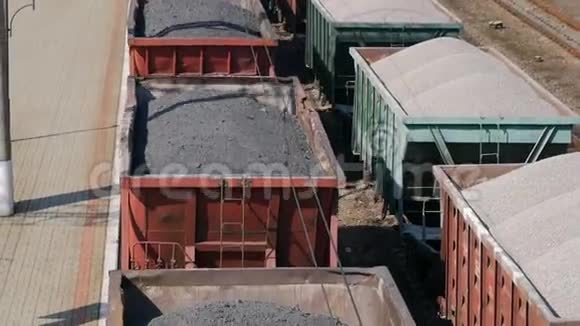 带货车的货运列车和带煤的站立列车的航空视野视频的预览图