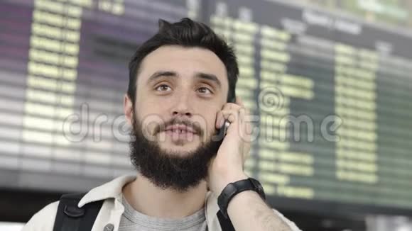 站在机场的胡子男在电话里说话视频的预览图