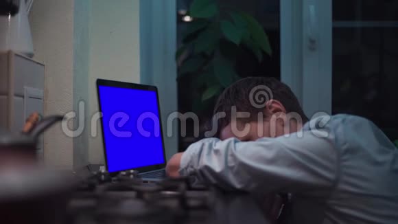 在灶台附近的厨房里看着蓝色钥匙笔记本电脑的人视频的预览图