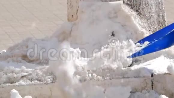 用铲子从街上手动铲白雪清除冰冻的小径冬季工作和清除大雪视频的预览图