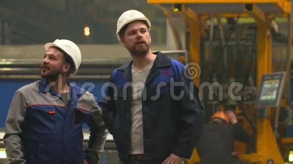 在重工业工厂两位工程师微笑着握手视频的预览图