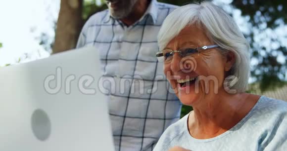 花园4k的快乐老年妇女使用笔记本电脑视频的预览图