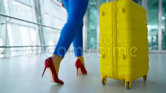 穿着鲜艳衣服的女人进入机场的电梯视频的预览图