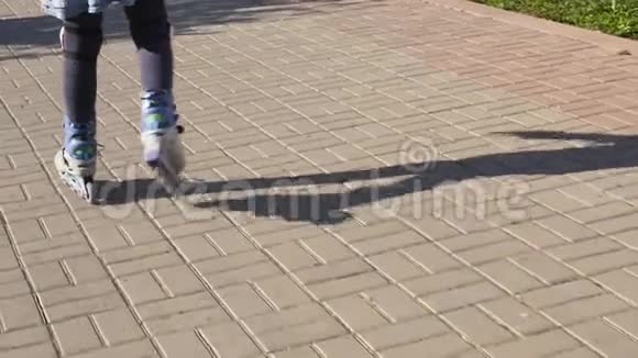 穿滑轮鞋的小孩的腿儿童卷在帕布里克公园慢动作视频的预览图