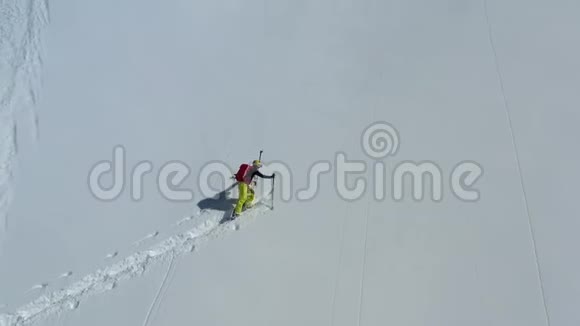 一名滑雪板上的男子正在攀登一座覆盖着新鲜粉末雪的山空中拍摄的画面是4k视频的预览图