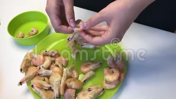 女人清理煮虾桌子上的下一个是蔬菜和豆腐块视频的预览图