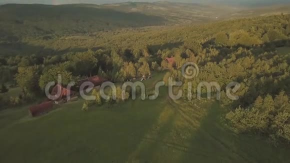 空中视野飞行山谷和山丘上长满了绿树和彩虹视频的预览图