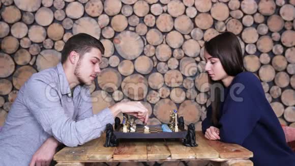 年轻的白种人夫妇在家里一起下棋背景是一个木框视频的预览图