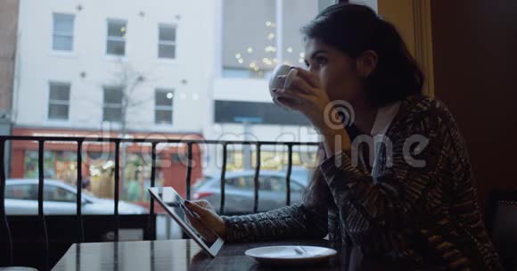 漂亮的年轻女孩在咖啡馆里喝咖啡慢动作4k视频的预览图