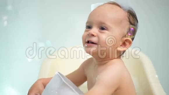 一岁小男孩洗澡和玩肥皂泡的慢镜头视频的预览图