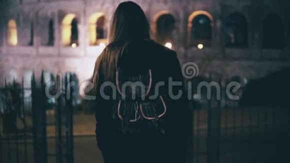 年轻的黑发女人来到楼下对面的罗马竞技场意大利深夜在城里散步的女孩视频的预览图