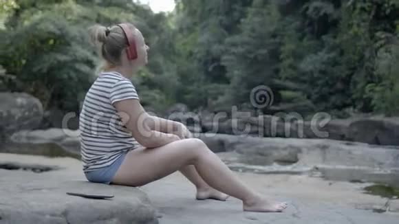 戴耳机的女孩在大自然中听音乐别紧张视频的预览图