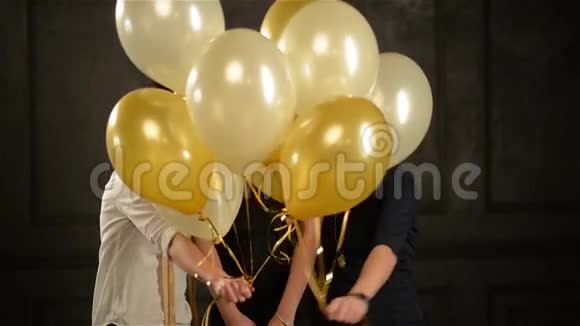 令人兴奋的女人在聚会时躲在气球里玩得很开心三个微笑女孩的特写镜头视频的预览图