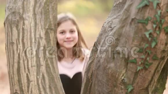 站在树旁的女孩挥手视频的预览图
