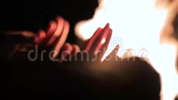 一对夫妇晚上在篝火旁牵手与朋友一起篝火晚会视频的预览图